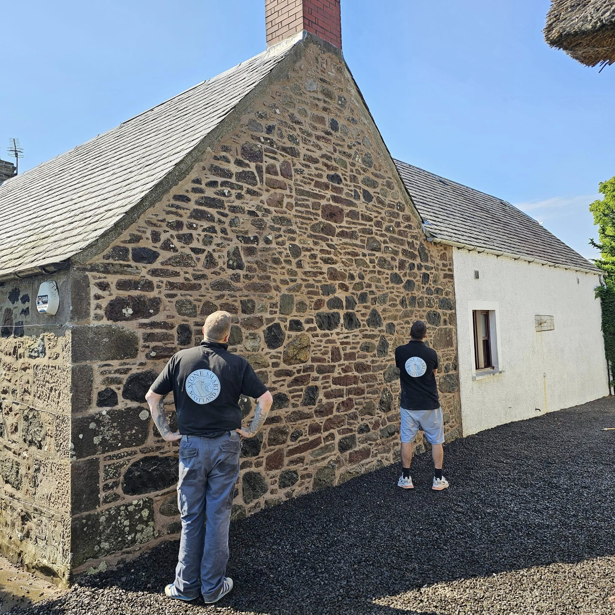 Stone Smart Scotland stonemasons inspecting a freshly repointed sandstone gable